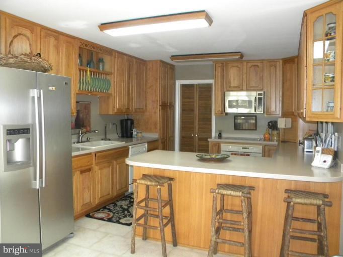 11317 Vale Road Oakton, VA 22124 - Photo 11 of 29 a kitchen with stainless steel appliances granite countertop a sink refrigerator and cabinets