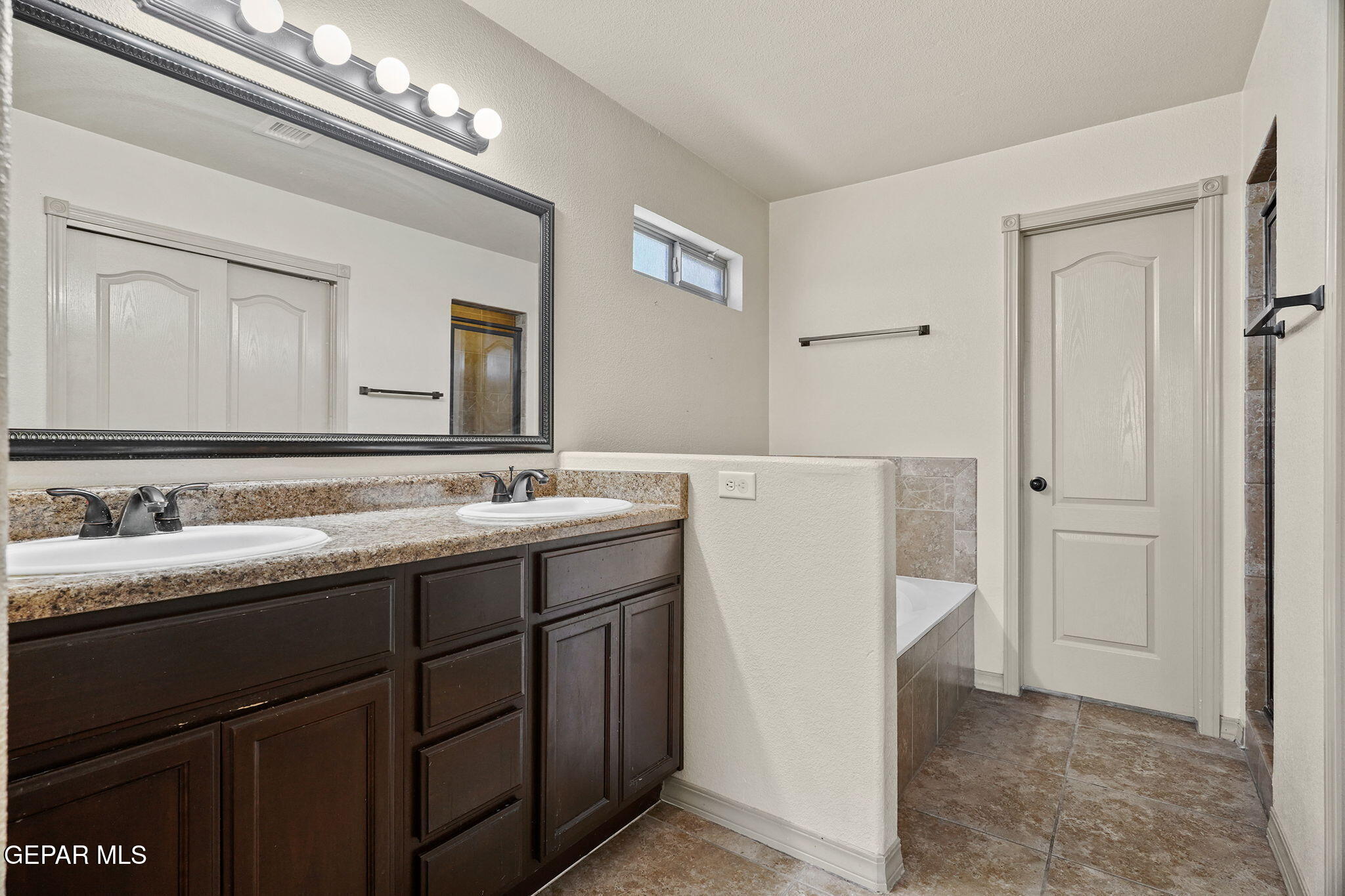3152 Rustic Hidden Drive El Paso, TX 79938 - Photo 19 of 38 a bathroom with a double vanity sink and a mirror