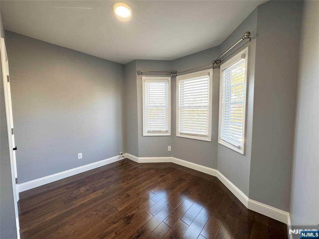 243 Hamilton Place, Unit 2 Hackensack, NJ 07601 - Photo 5 of 9 a view of an empty room with wooden floor and a window