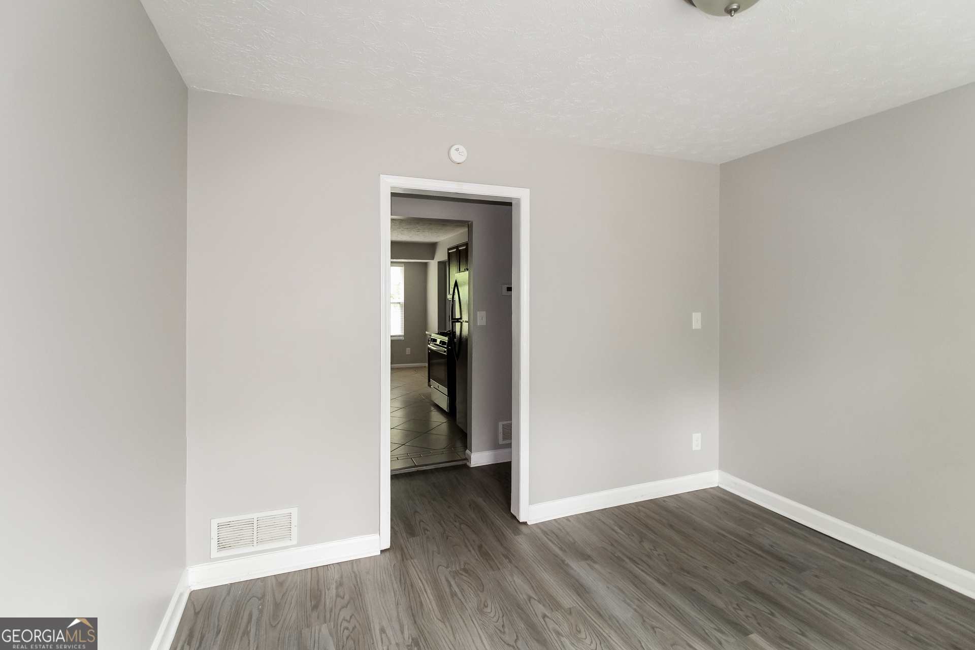 858 Martin Road Stone Mountain, GA 30088 - Photo 3 of 15 a view of a livingroom with wooden floor and a refrigerator