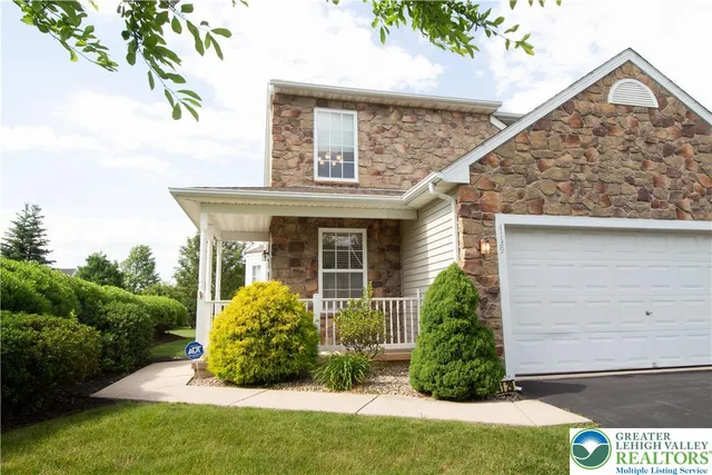 a view of a house with brick walls and a yard with potted plants