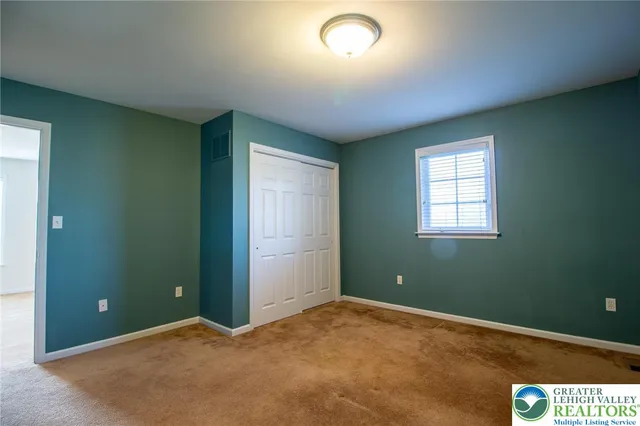 an empty room with windows and closet