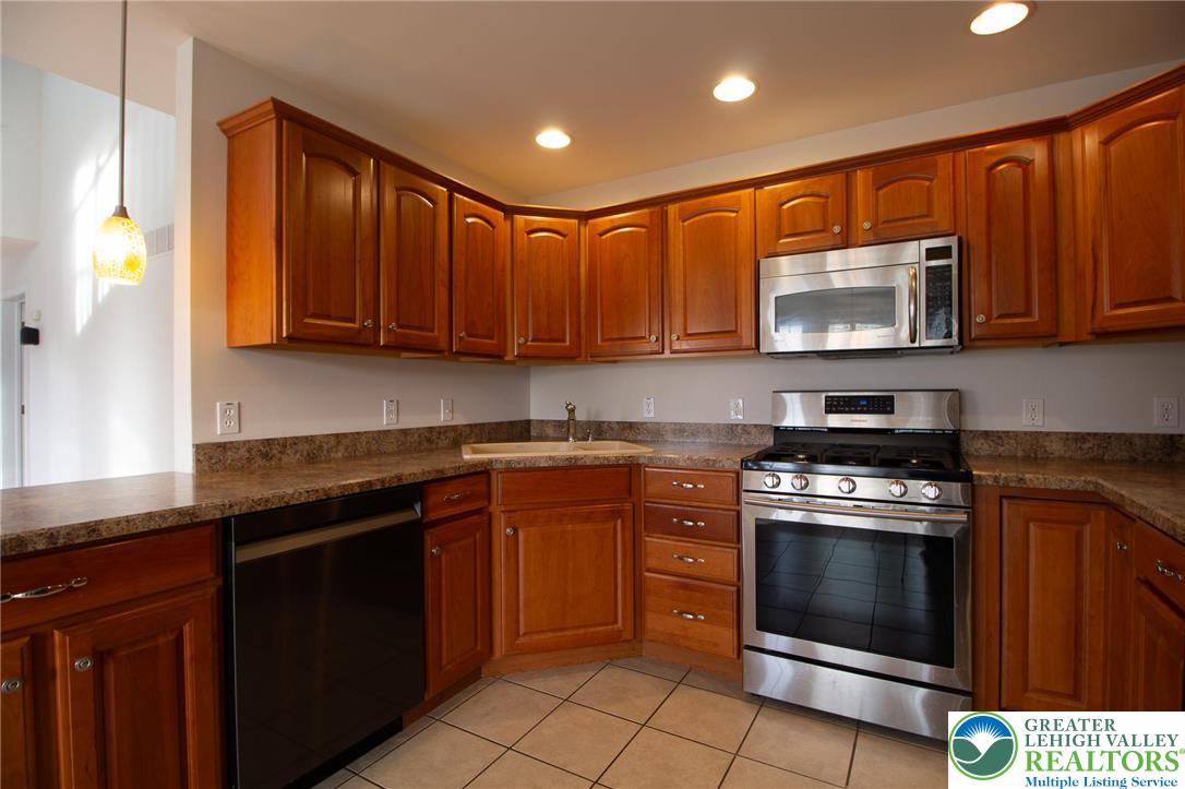 4129 Coleman Street Bethlehem, PA 18020 - Photo 8 of 36 a kitchen with stainless steel appliances granite countertop wooden cabinets stove top oven and microwave