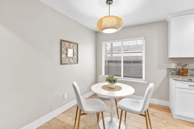 a dining room with furniture a window and wooden floor