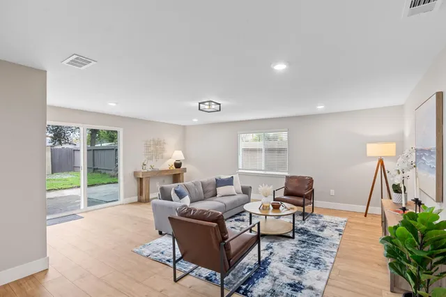a living room with furniture and a floor to ceiling window