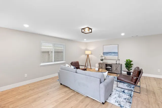 a living room with furniture and a wooden floor