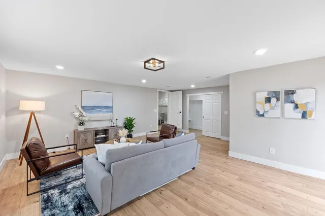 a living room with furniture and a wooden floor