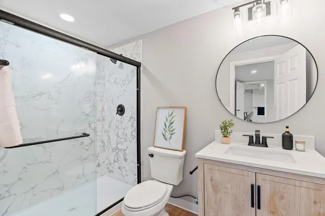 a bathroom with a sink a toilet and a mirror