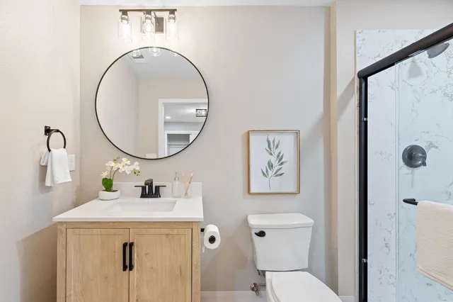 a bathroom with a sink a mirror a toilet and a mirror