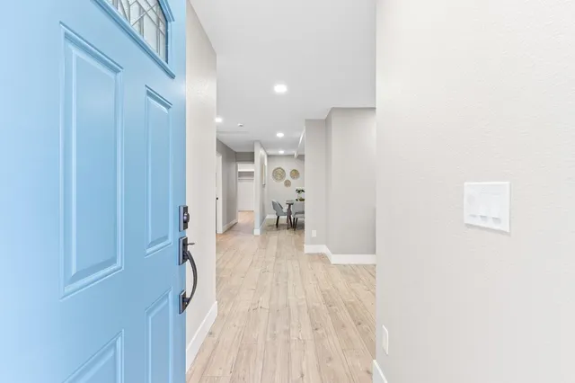 a view of a hallway with wooden floor windows and a bathroom