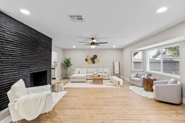 a living room with furniture fireplace and a large window