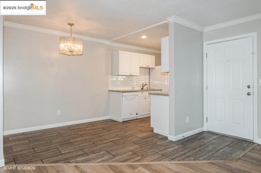 1505 Kirker Pass Road, Unit 170 Concord, CA 94521 - Photo 5 of 18 Kitchen featuring decorative backsplash, white cabinetry, dark wood-style flooring, crown molding, and dishwasher