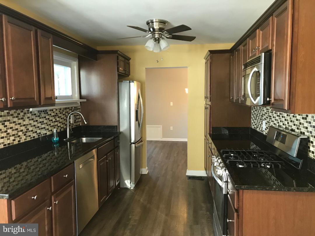 2461 Woodcroft Road Baltimore, MD 21234 - Photo 7 of 33 Glass tile back plash and wood flooring.