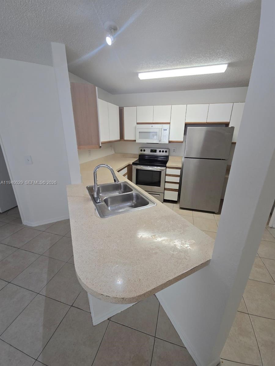 4035 West McNab Road, Unit F210 Pompano Beach, FL 33069 - Photo 11 of 22 a view of kitchen with refrigerator and stove