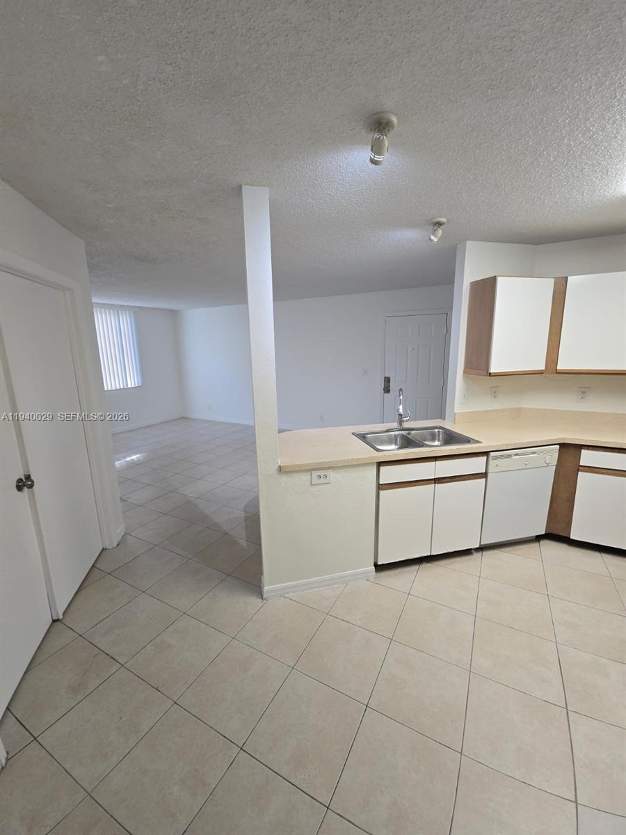 4035 West McNab Road, Unit F210 Pompano Beach, FL 33069 - Photo 4 of 22 a kitchen with a stove a sink and a refrigerator