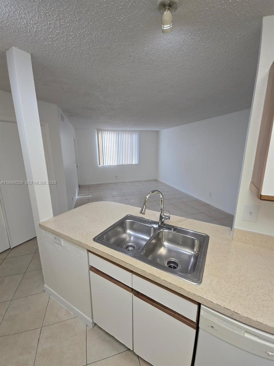4035 West McNab Road, Unit F210 Pompano Beach, FL 33069 - Photo 5 of 22 a room with a sink a washer and dryer