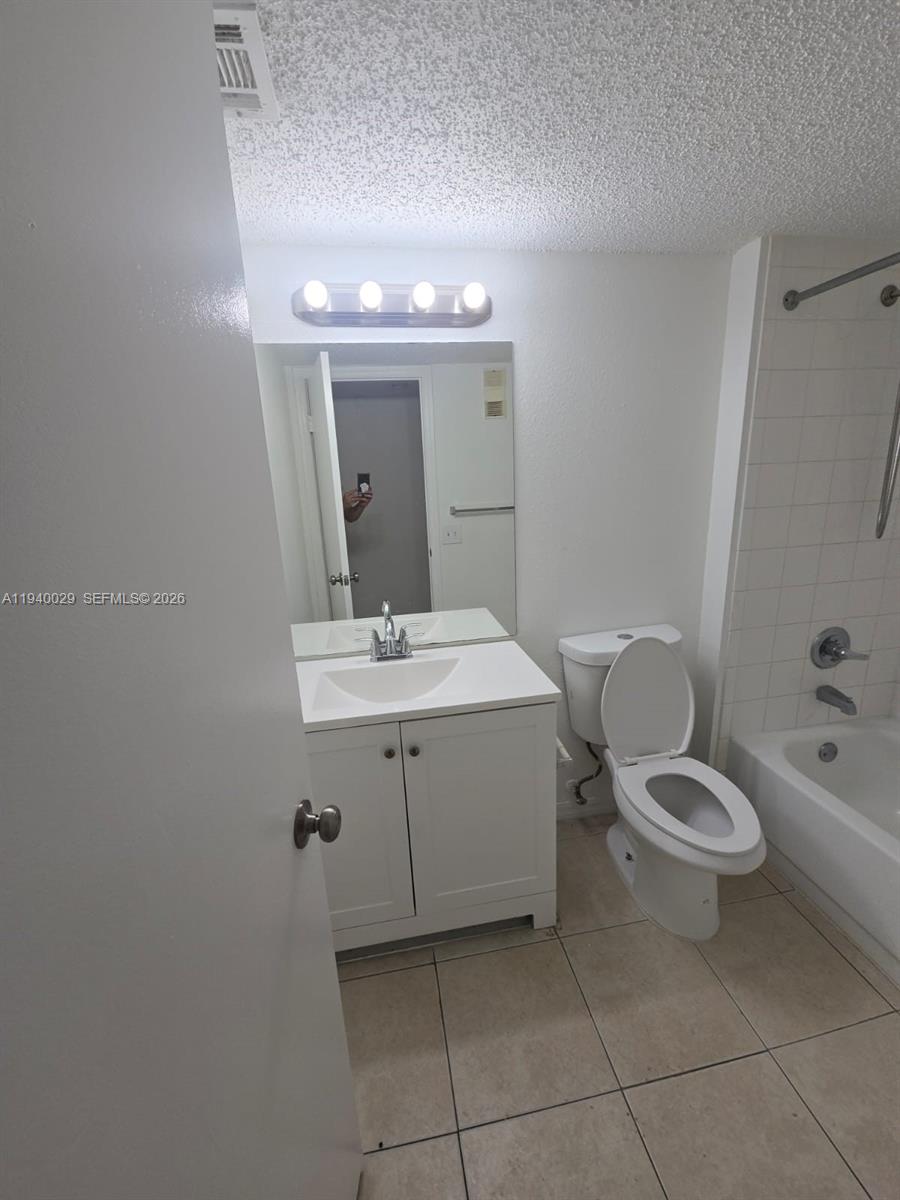 4035 West McNab Road, Unit F210 Pompano Beach, FL 33069 - Photo 7 of 22 a bathroom with a toilet sink and mirror