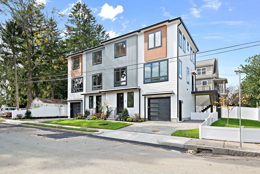 25 Tolman Street, Unit 1 Waltham, MA 02453 - Photo 1 of 36 a front view of a house with a garden and plants