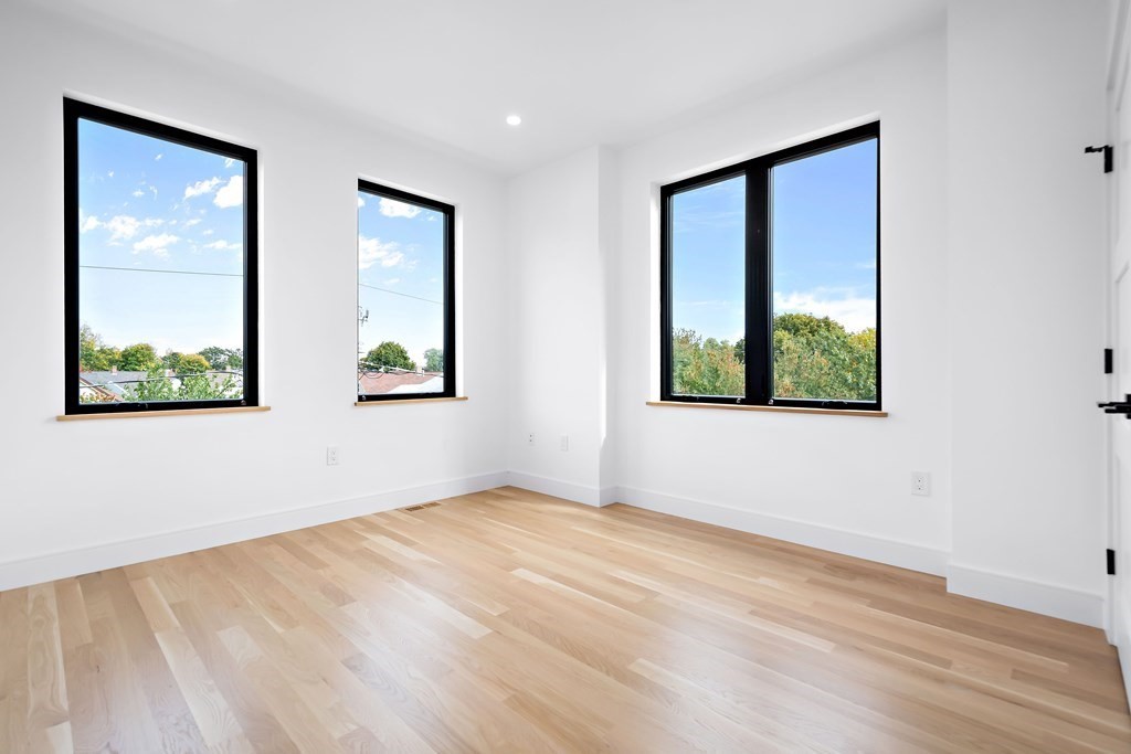 25 Tolman Street, Unit 1 Waltham, MA 02453 - Photo 16 of 36 a view of an empty room with wooden floor and windows