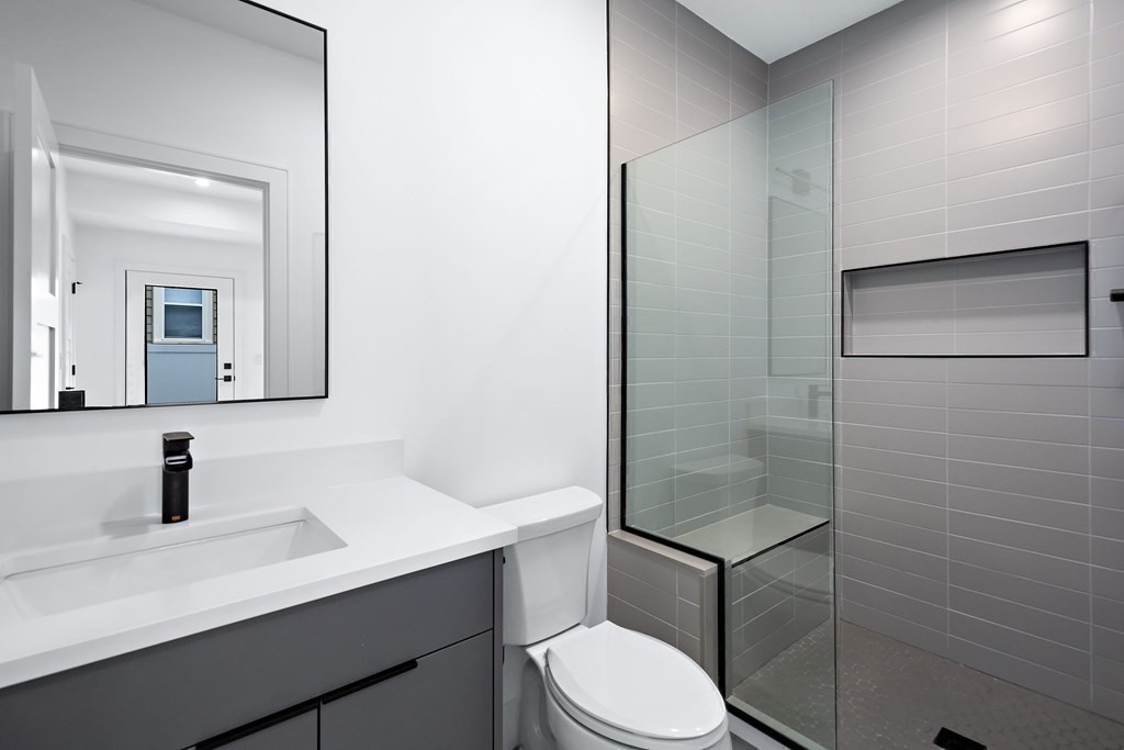 25 Tolman Street, Unit 1 Waltham, MA 02453 - Photo 24 of 36 a bathroom with a sink a toilet a shower and mirror