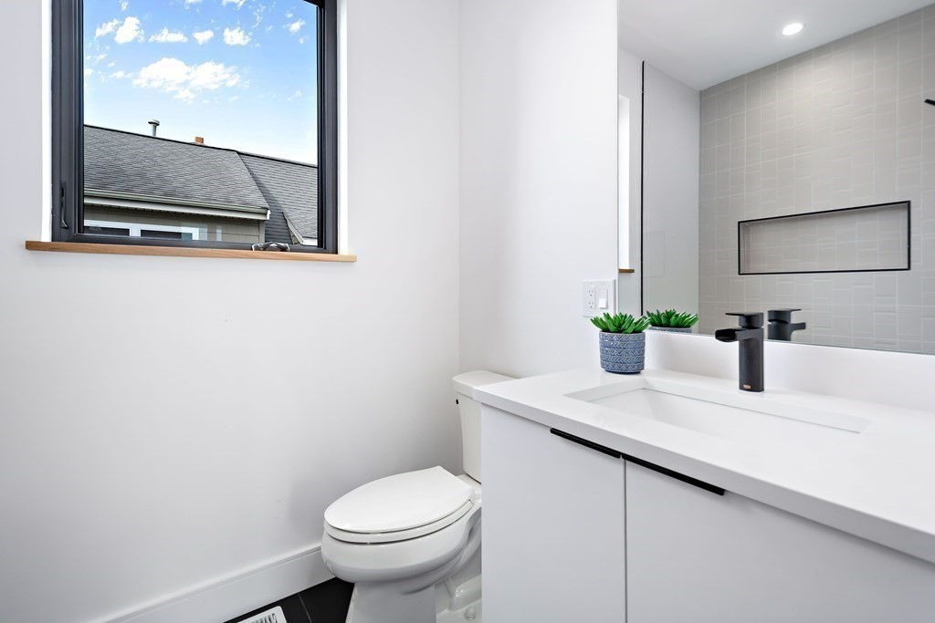 25 Tolman Street, Unit 1 Waltham, MA 02453 - Photo 26 of 36 a bathroom with a toilet sink and mirror