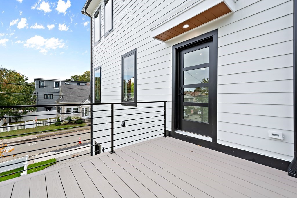 25 Tolman Street, Unit 1 Waltham, MA 02453 - Photo 32 of 36 a view of a balcony with wooden floor and fence