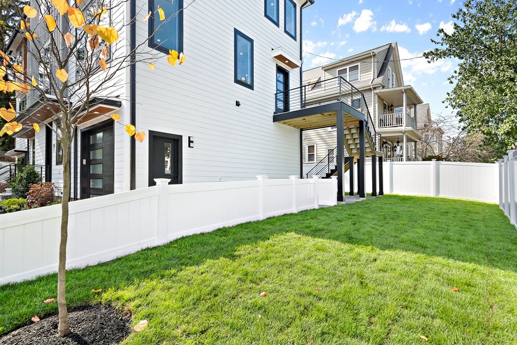 25 Tolman Street, Unit 1 Waltham, MA 02453 - Photo 36 of 36 a front view of a house with a yard and garage