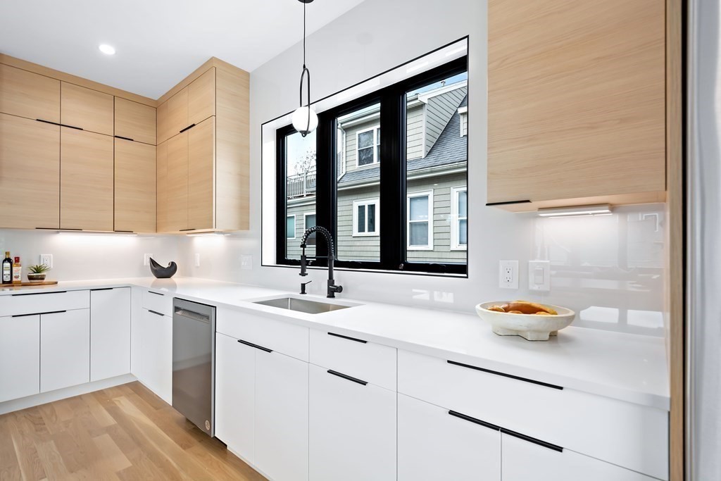 25 Tolman Street, Unit 1 Waltham, MA 02453 - Photo 7 of 36 a kitchen with stainless steel appliances granite countertop cabinets sink and wooden floor