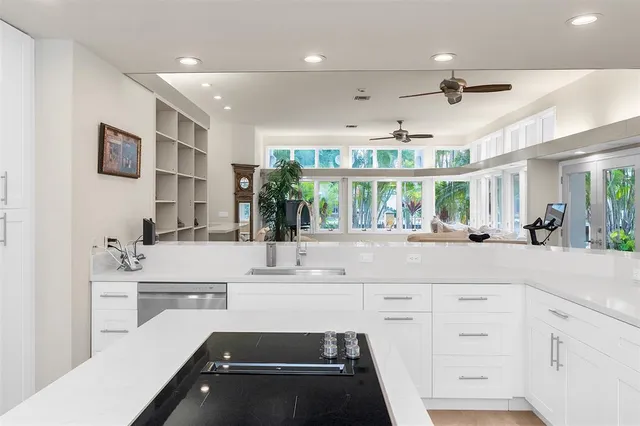 a bedroom with white bed and a window