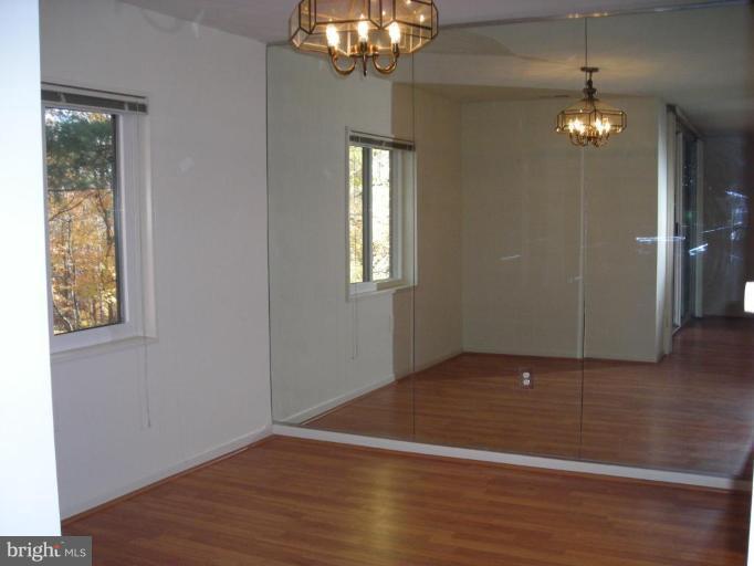 1554 Northgate Square, Unit 54/31B Reston, VA 20190 - Photo 5 of 15 an empty room with wooden floor chandelier and windows