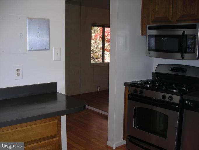 1554 Northgate Square, Unit 54/31B Reston, VA 20190 - Photo 8 of 15 a kitchen with wooden cabinets and a stove top oven