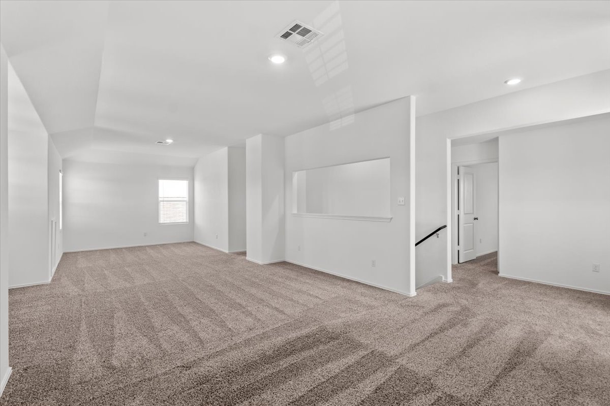 448 Perfect World Loop Jarrell, TX 76537 - Photo 33 of 40 A spacious open-concept room features plush carpeting and well-lit interiors.