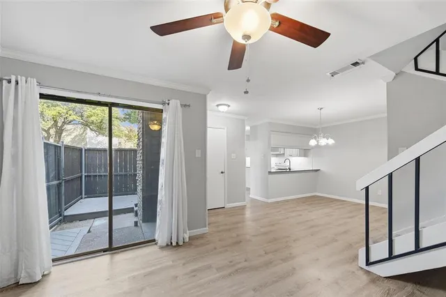 a view of a kitchen with a sink wooden cabinets and a window