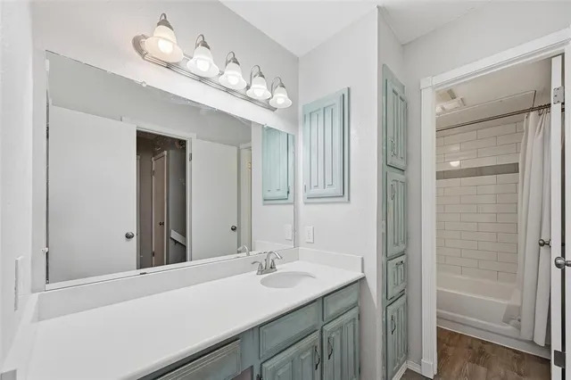 an empty room with wooden floor closet and windows