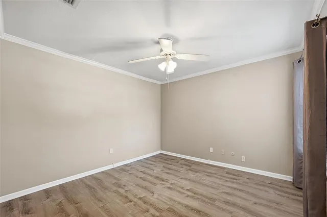 a view of a room with wooden floor and a ceiling fan