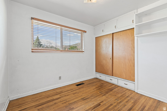 542 East 3400th Street North Provo, UT 84604 - Photo 23 of 39 Hardwood flooring complemented by a window with horizontal blinds and built-in white cabinetry featuring wood-finish sliding doors and lower drawers