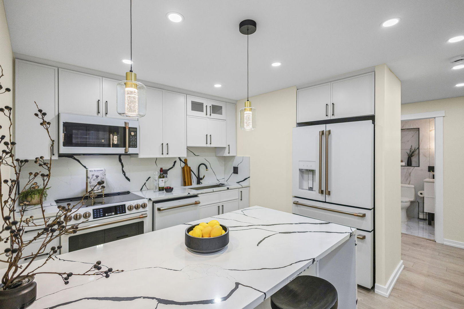 100 East Walton Street, Unit 14D Chicago, IL 60611 - Photo 9 of 36 a kitchen with stainless steel appliances a stove a refrigerator and white cabinets