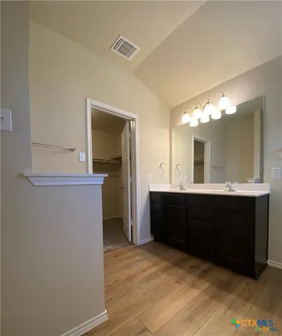 a spacious bathroom with a double vanity sink and a mirror
