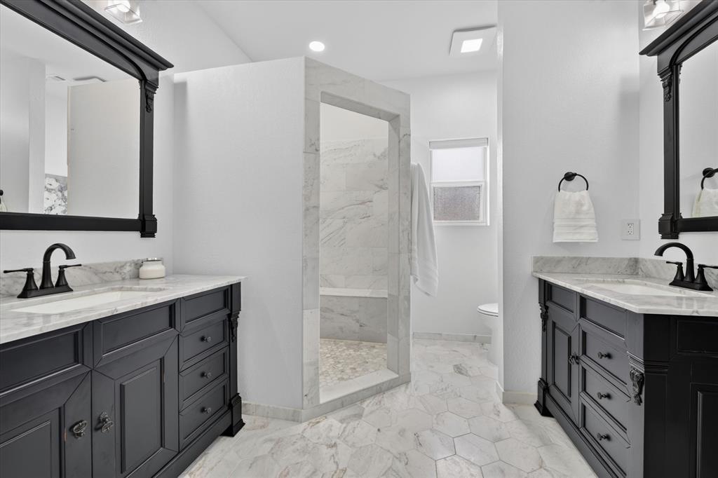 421 Ben Boyd Road Argyle, TX 76226 - Photo 10 of 25 Dual vanity bathroom featuring black cabinetry, white countertops, and black framed mirrors