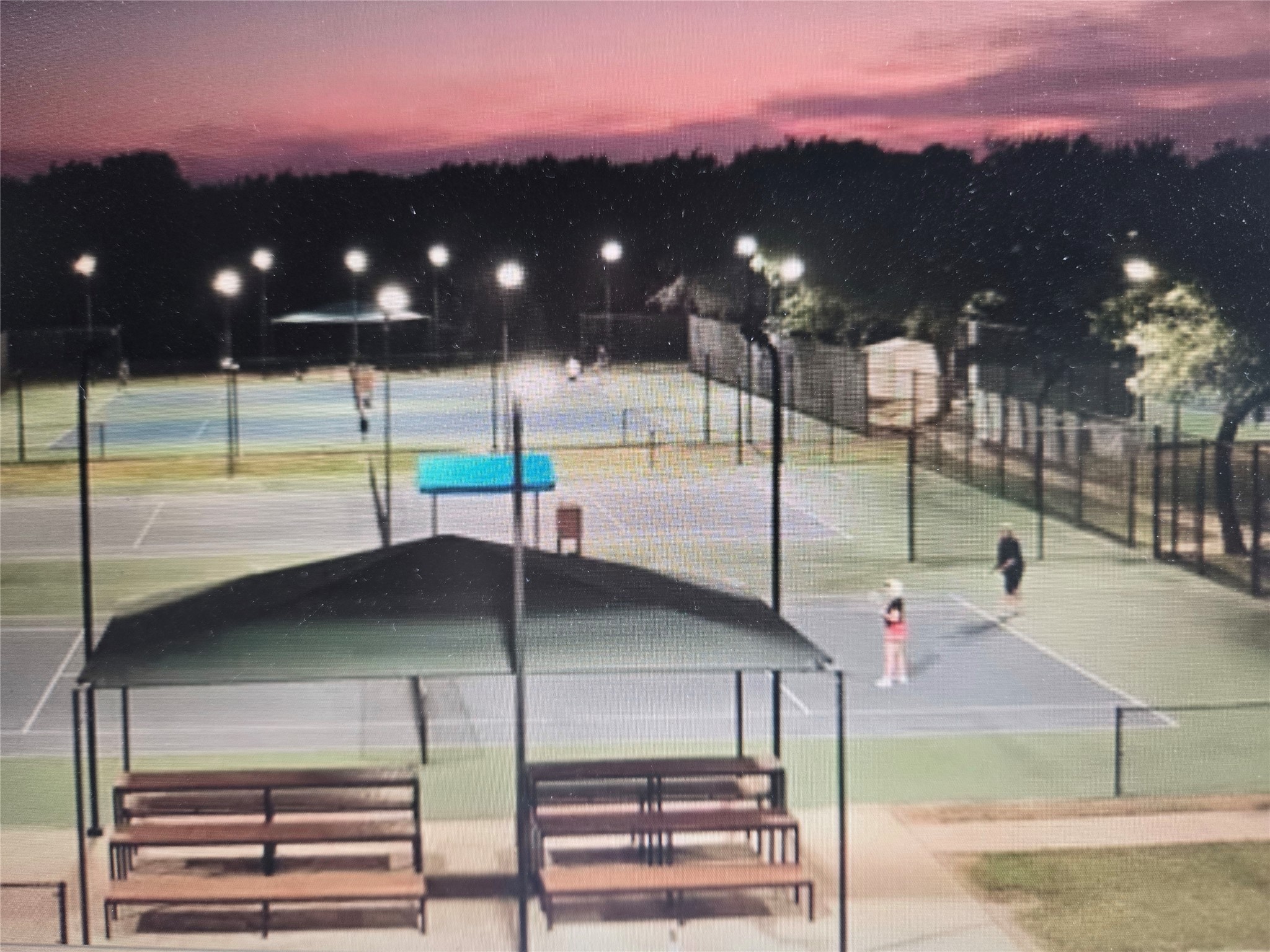 30013 Edgewood Drive Georgetown, TX 78628 - Photo 38 of 39 Sports and Golf memberships include lighted Tennis and Pickleball courts with evening lighting, surrounded by fencing and trees