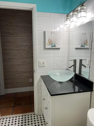 a bathroom with a granite countertop sink and a mirror