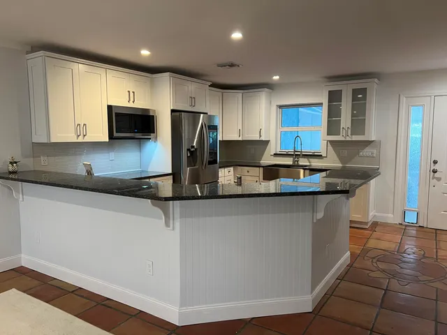 a kitchen with stainless steel appliances a refrigerator sink and cabinets