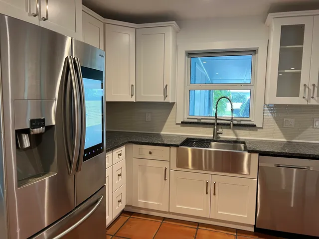 a kitchen with a sink cabinets and chandelier