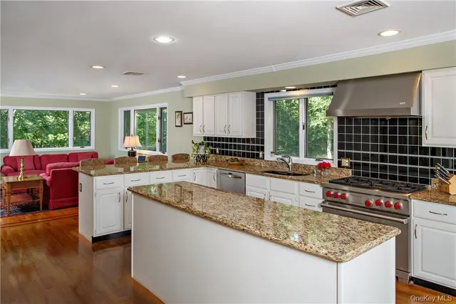a kitchen with stainless steel appliances granite countertop sink stove and wooden cabinets
