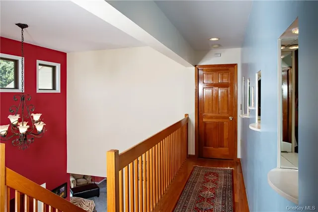 a view of a hallway with wooden floor and stairs