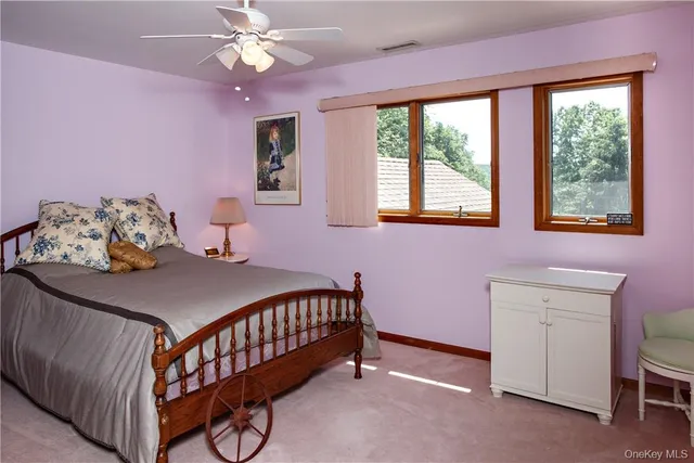 a bedroom with a bed and a chandelier fan