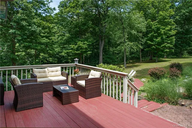 a view of a deck with couches chair and wooden floor