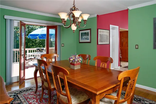 a view of a dining room with furniture a chandelier and window