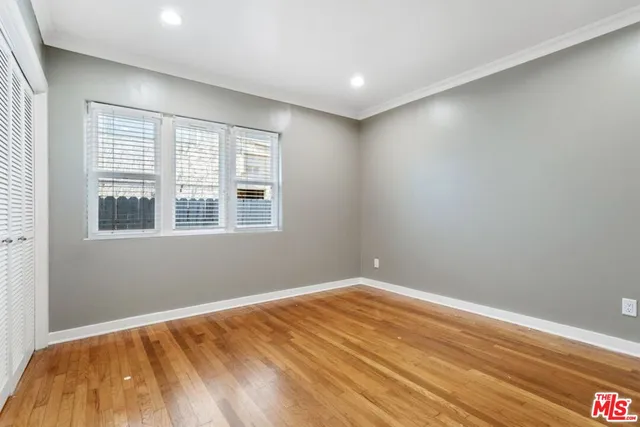 a view of empty room with wooden floor