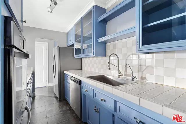 a kitchen with stainless steel appliances granite countertop a sink and a refrigerator